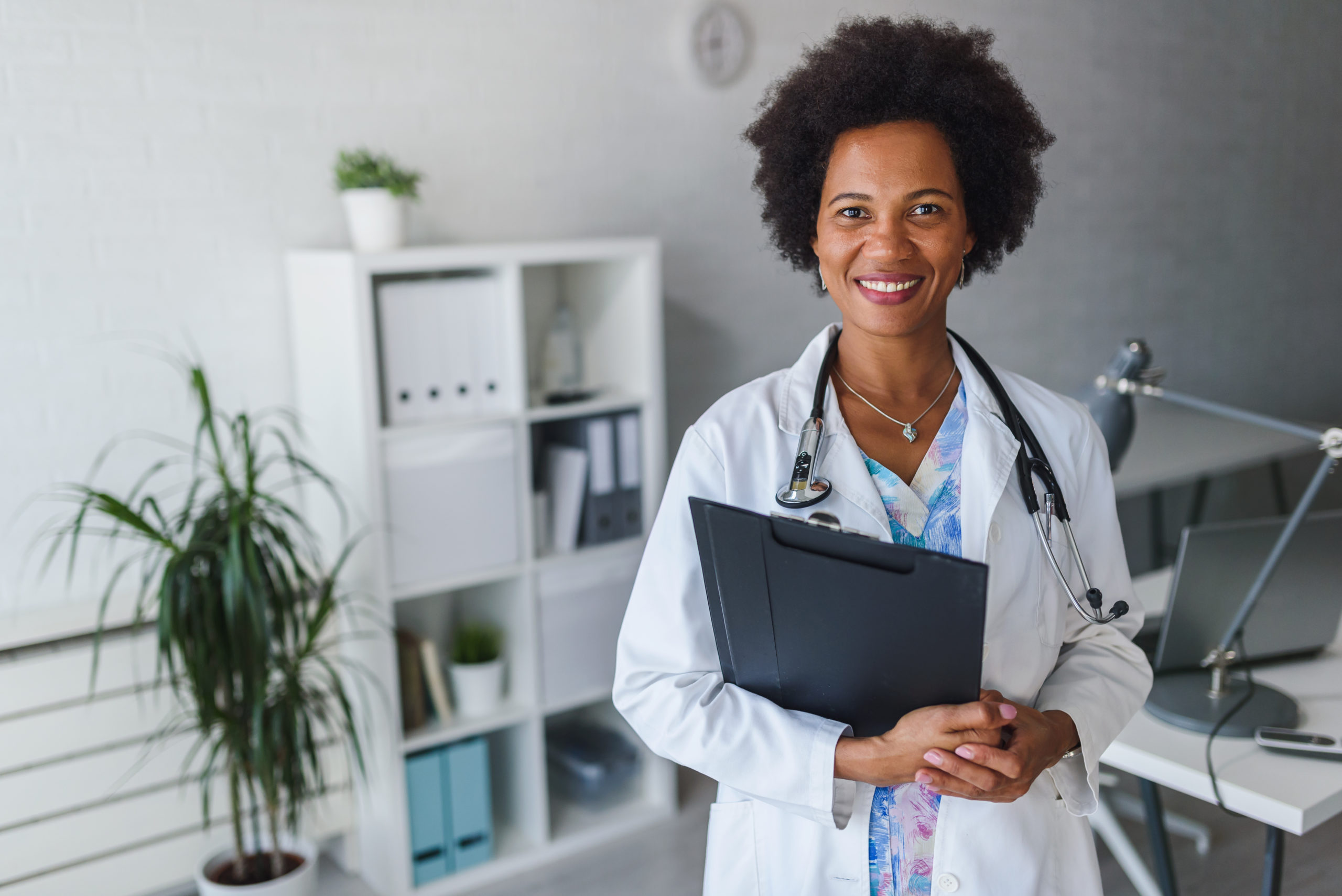 Portrait of female African American doctor standing in her office at clinic